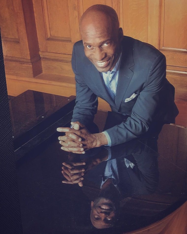 Black Male Leaning On A Piano